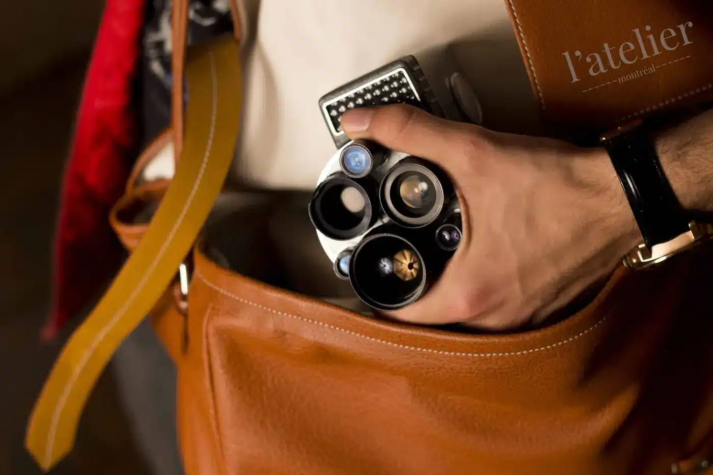 Une main sort un appareil photo ancien d’un sac en cuir, photo de produit par Domrob Films